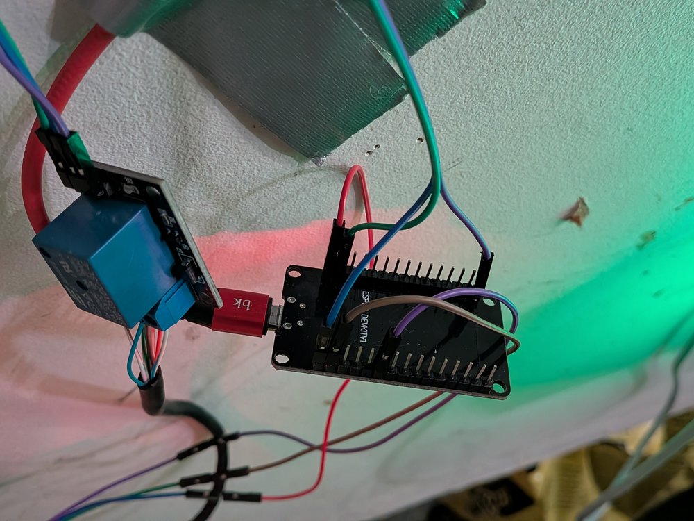 ESP32 DevKit V1, 5V relay module, and Hall-effect sensor wired and mounted on a wall